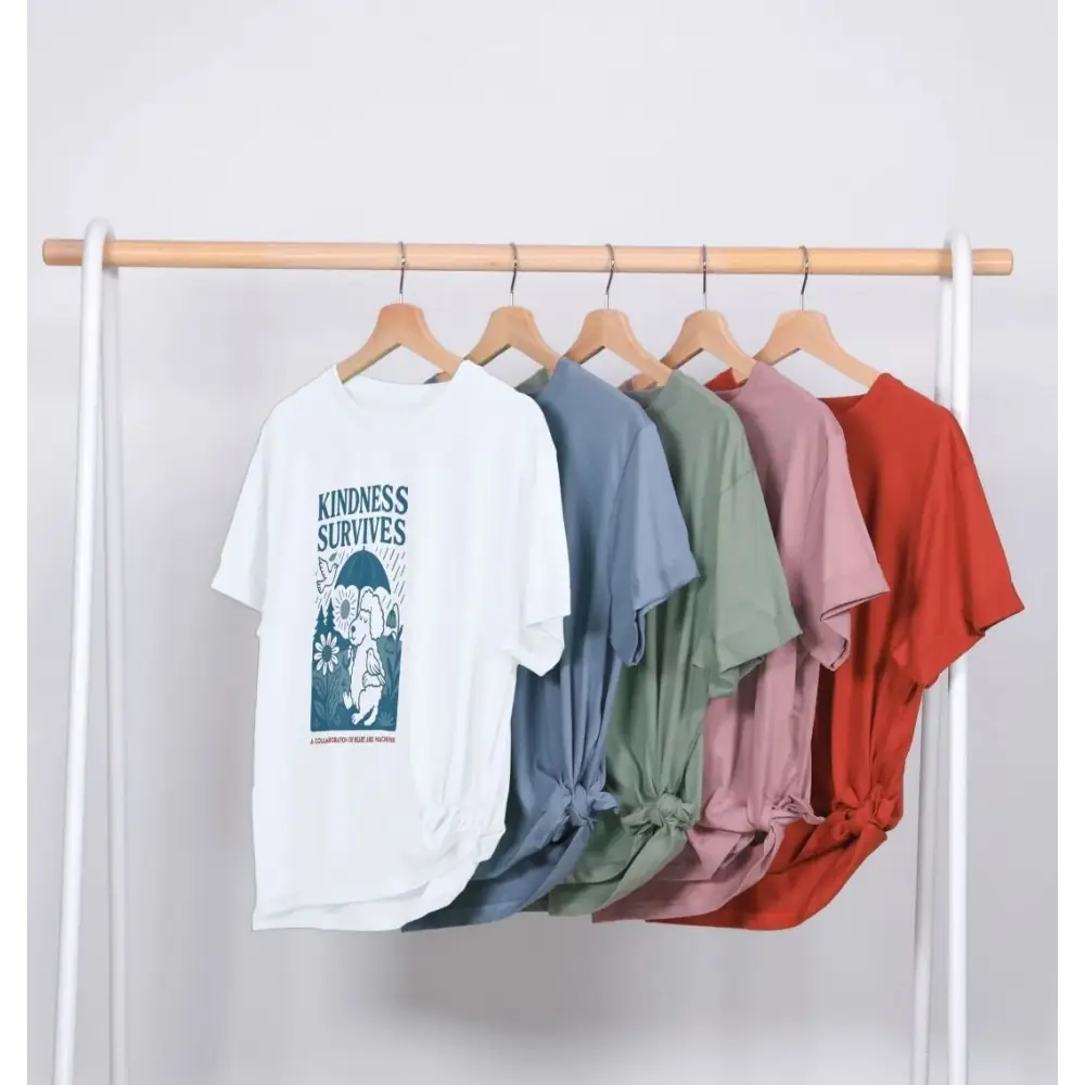 White kindness survives organic cotton T-shirt with colorful sleeves on wooden hanger