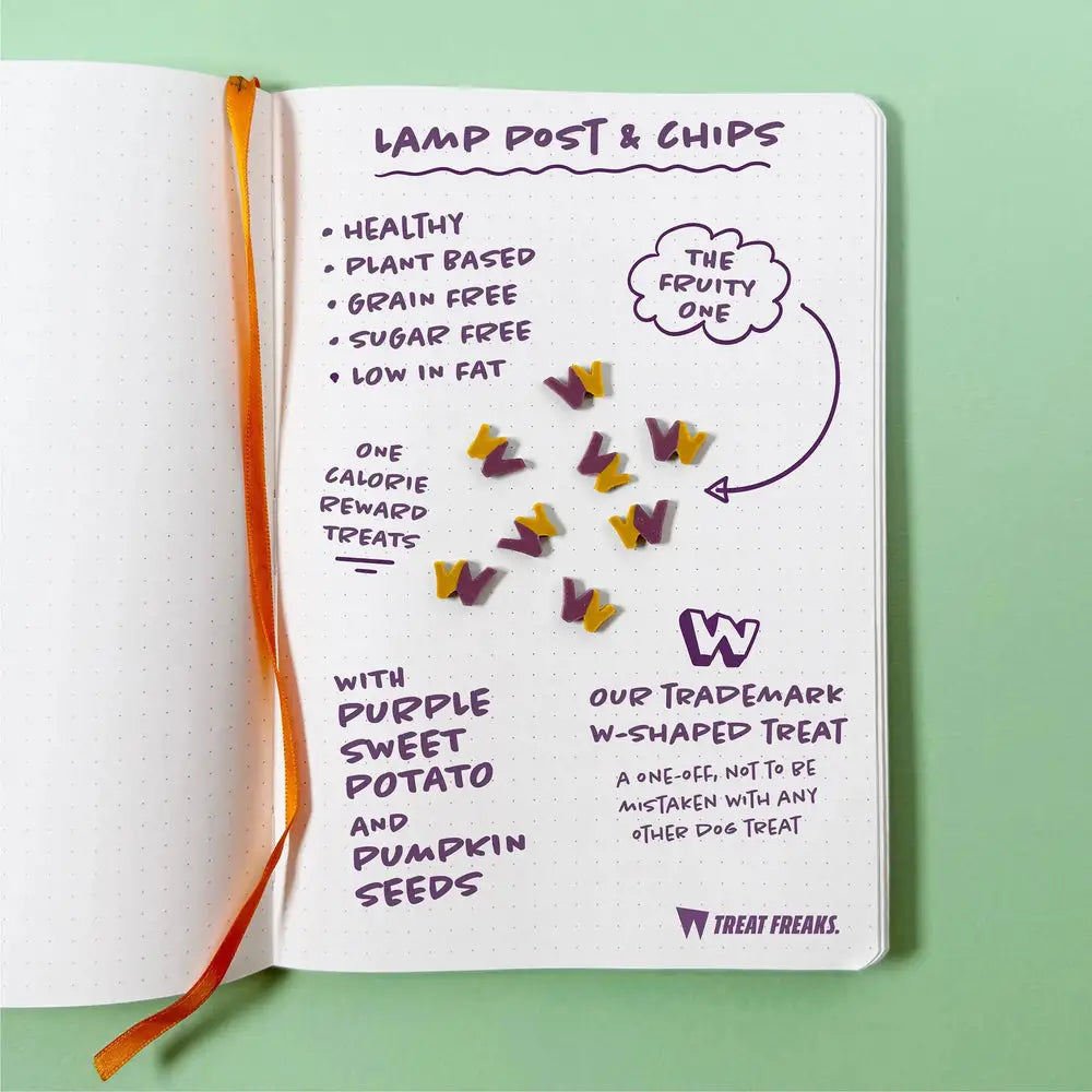 Purple and yellow w-shaped sweet potato dog treats from Lamp Post & Chips Pouch on notebook