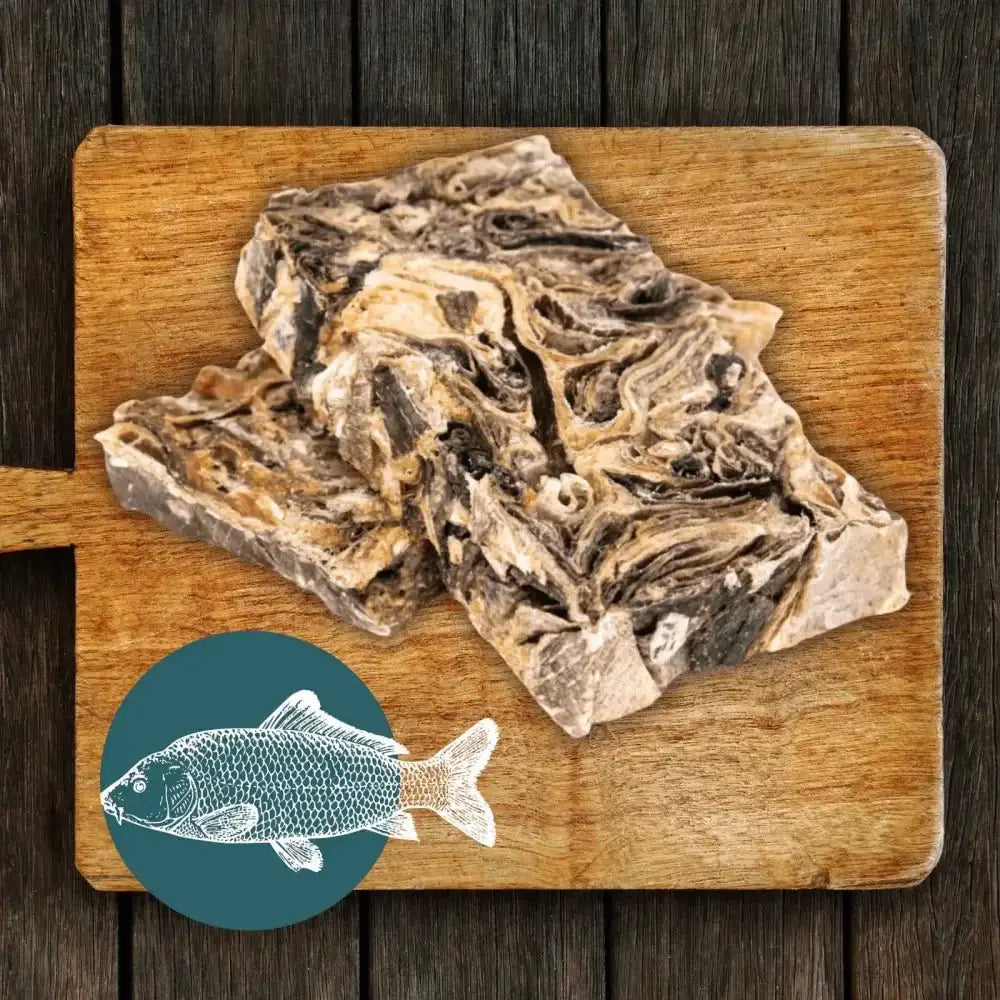 Wooden cutting board with raw mighty fish chews bones and teal fish bowl