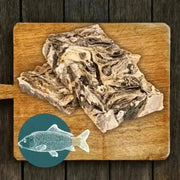 Wooden cutting board with raw mighty fish chews for dogs