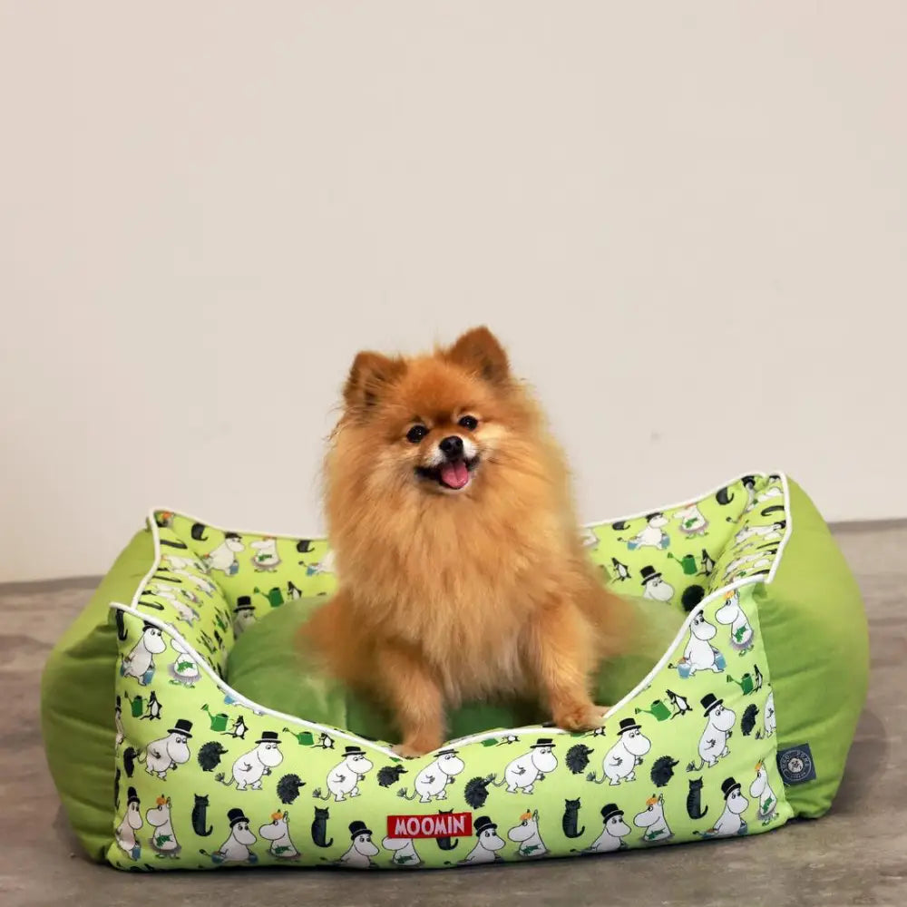 Lime green Moomins dog bed with white and black design, cushioned for comfort
