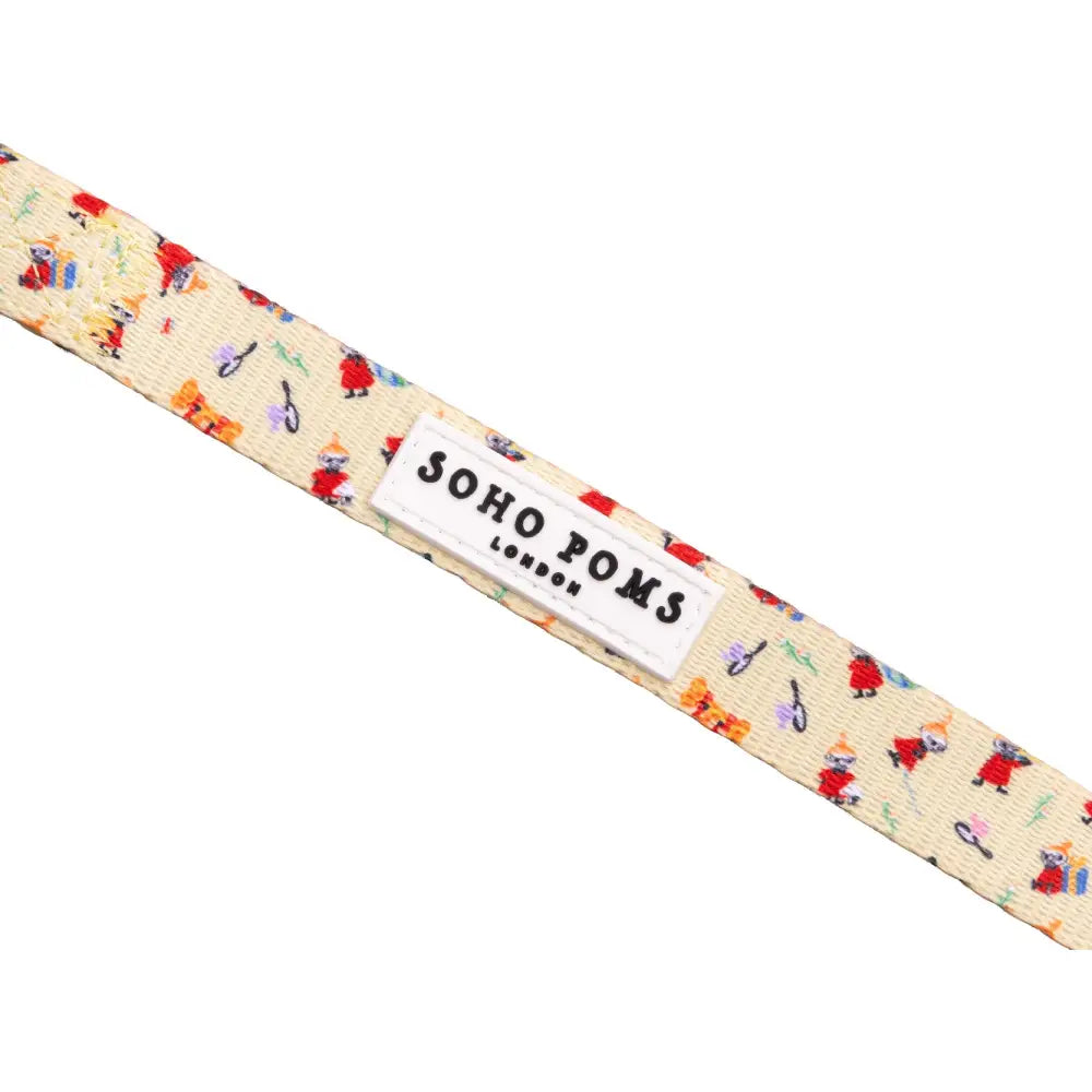 Cream-colored tie featuring whimsical cat and musical designs from Soho Poms Moomins Yellow Sunrise collection