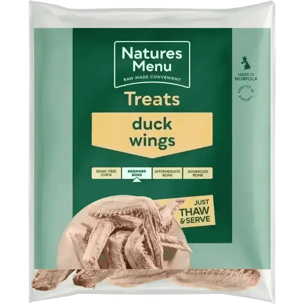 Raw responsibly sourced duck wings for dogs on wooden plate
