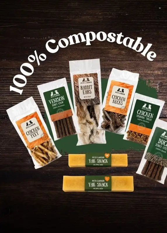 Packaged pet treats in clear and white bags with green and orange labels, featuring varieties like chicken felt, venison jerky sticks, rabbit ears, chicken necks, and duck jerky.