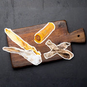 Wooden cutting board with dried meat slices from the Pick n Mix Bundle featuring rabbit ear and mix options