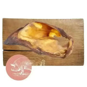Golden pig-shaped natural dog chew from Pets Larder on wooden board