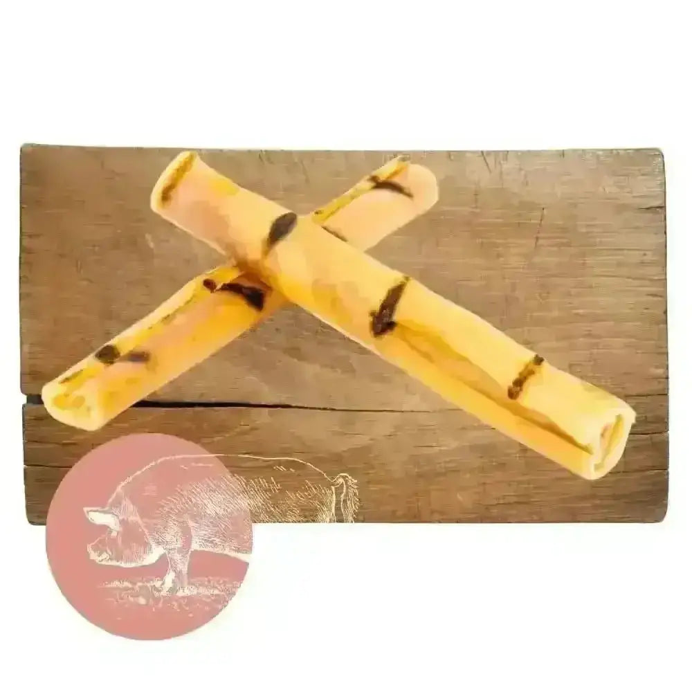 Yellow and black pork crackling sticks on wooden surface for dog chew product