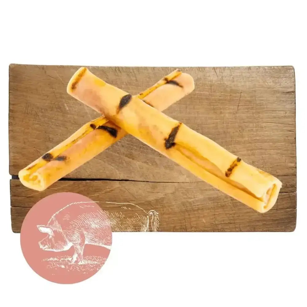Yellow and black pork crackling sticks on wooden surface for dog chew product