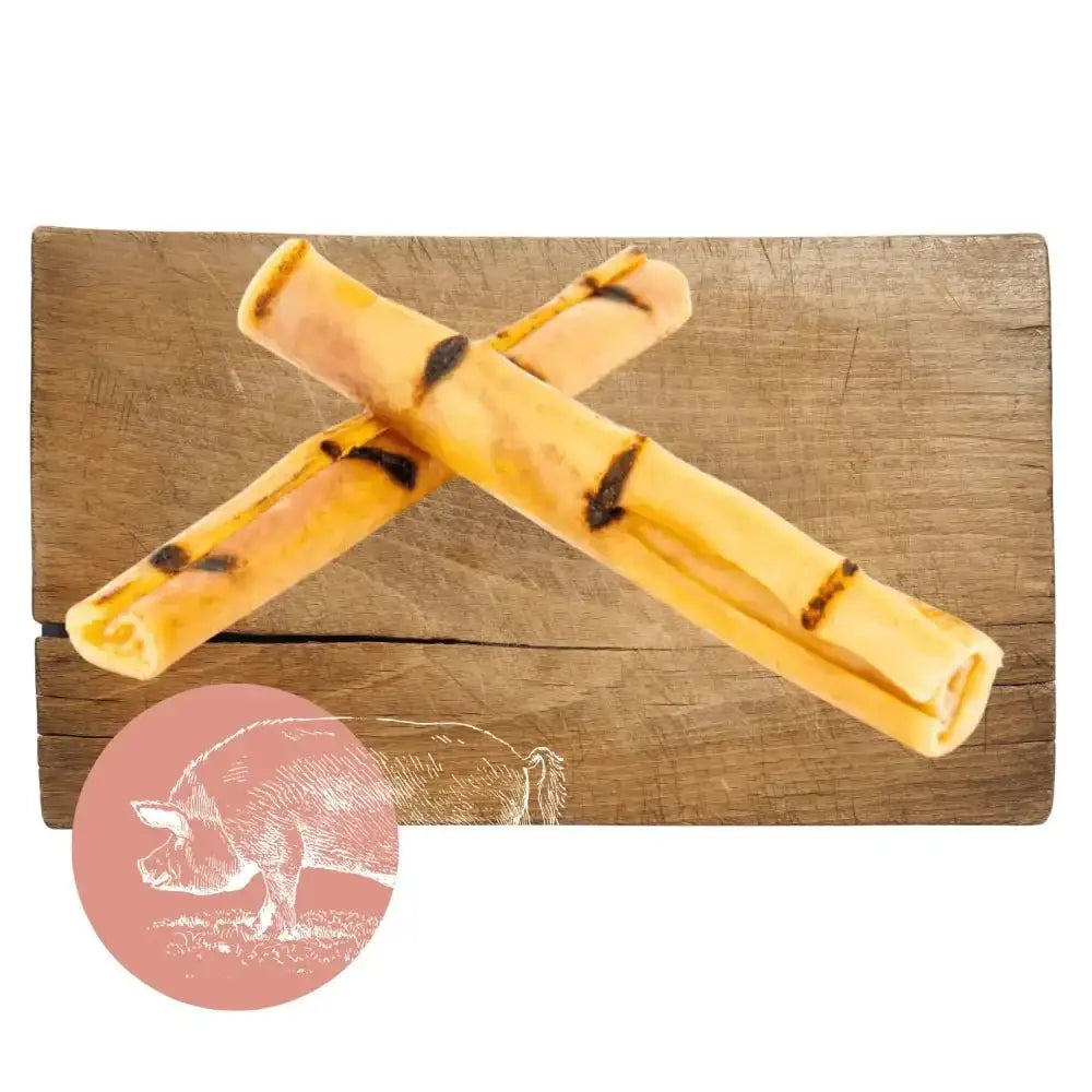 Yellow and black pork crackling sticks on wooden surface for dog chew product