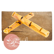 Yellow and black pork crackling sticks on wooden surface for dog chew product