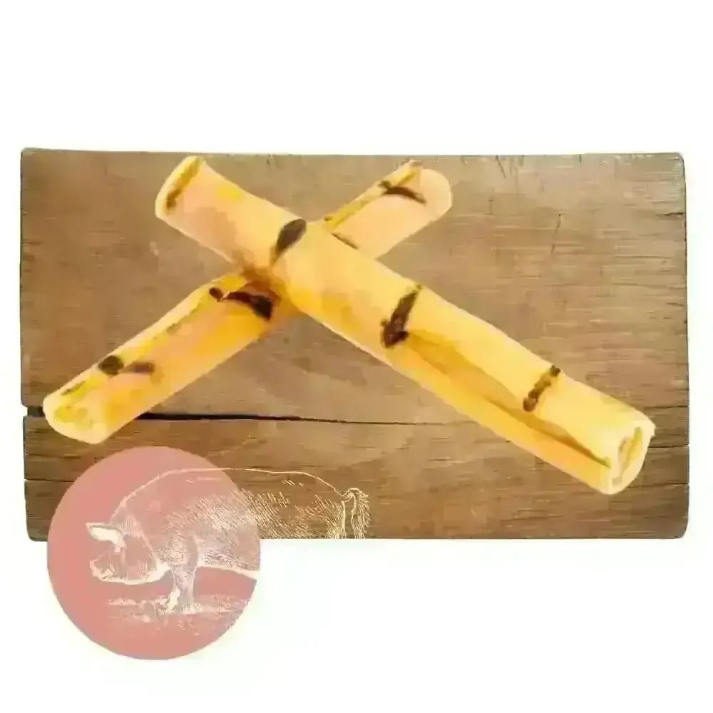 Yellow and black pork crackling sticks on wooden surface for dog chew product