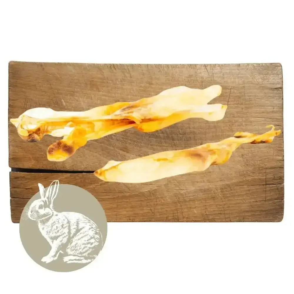 Rabbit ear natural meat chew for dogs on wooden board with cheese sticks