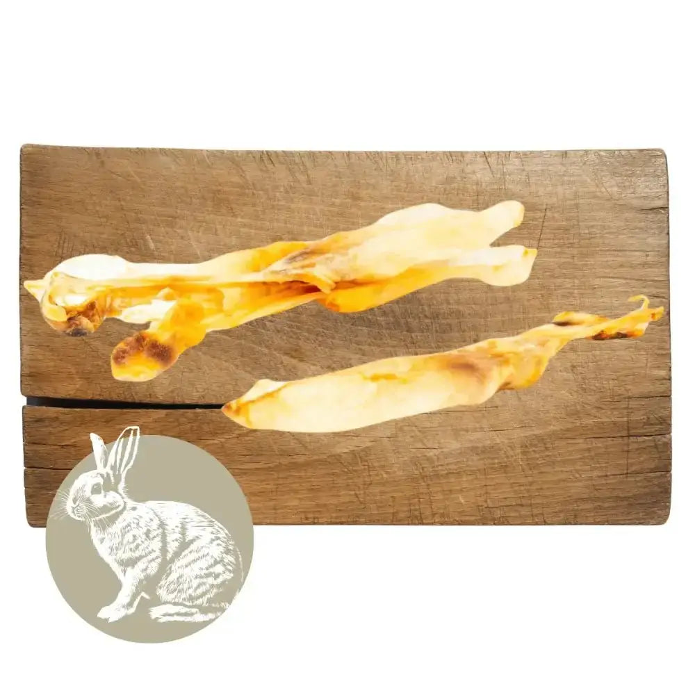 Rabbit ear natural meat chew for dogs on wooden board with cheese sticks