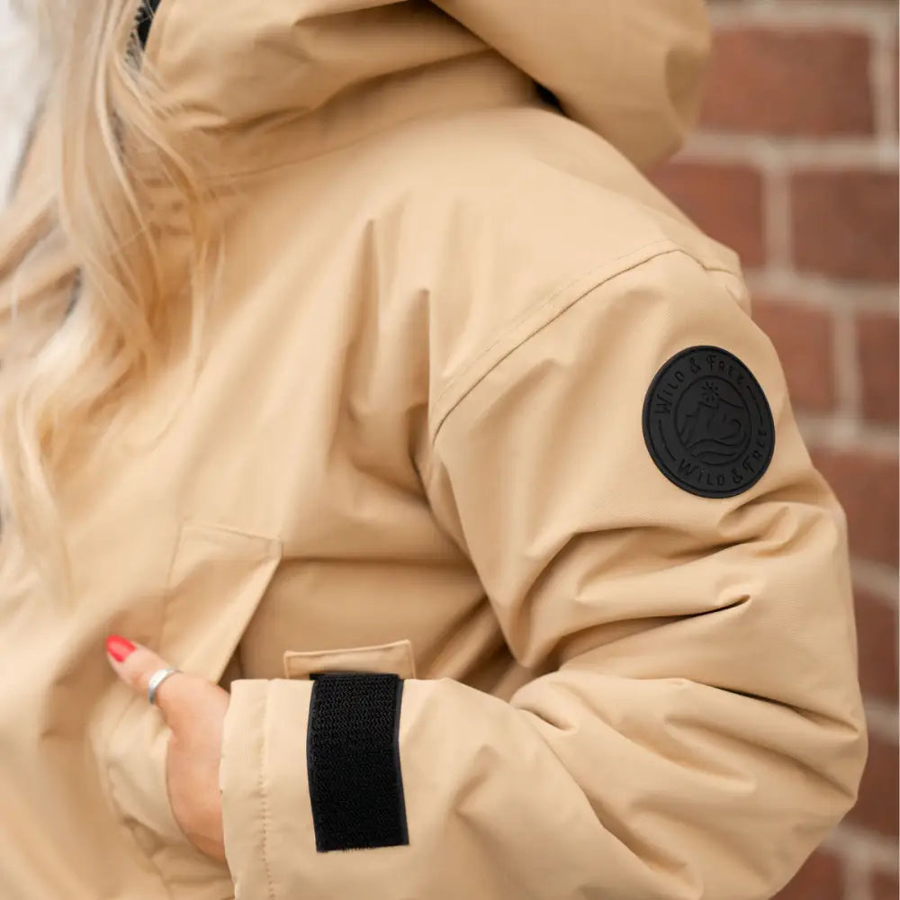 Beige Canada Goose down jacket with black accents as changing robe
