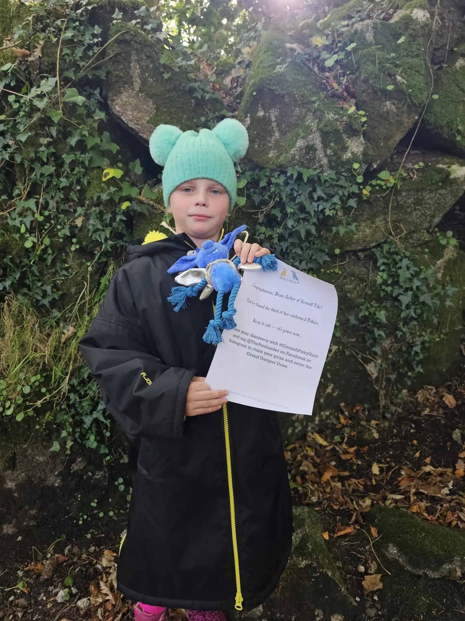 Teal plush bear hat with pom-poms, fleece material.