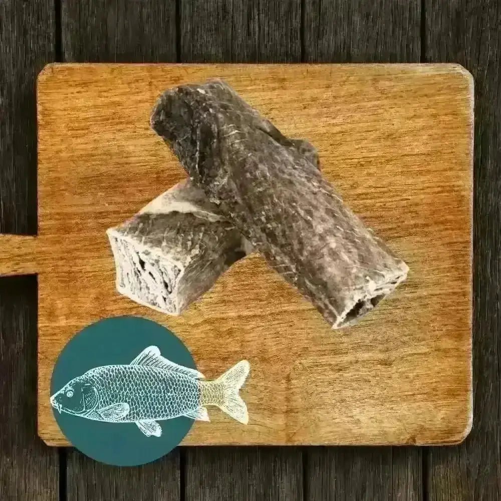 Fish stick dog treat in The Fish Chew Box on wooden board