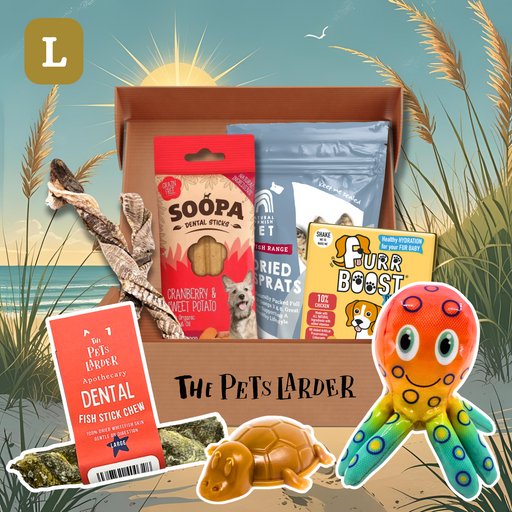 Pet product box with various pet items including treats and a toy, set against a beach scene.