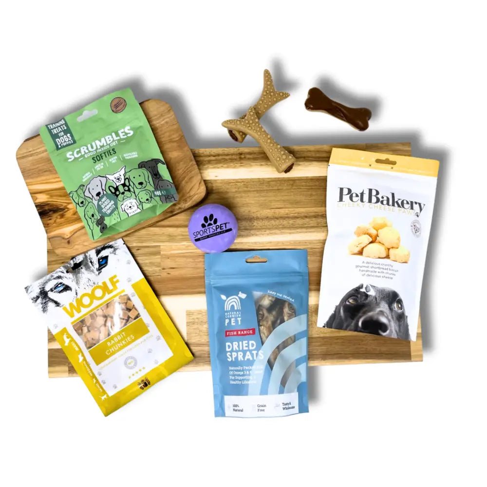 Wooden cutting board with dog treats and toys from The Pets Larder monthly treat box