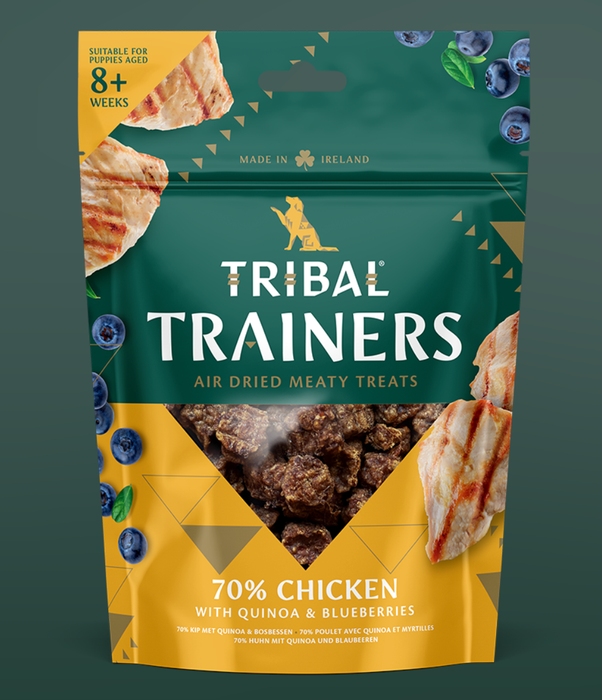 Tribal Trainers dog treat package with chicken, quinoa, and blueberry ingredients on a green background.