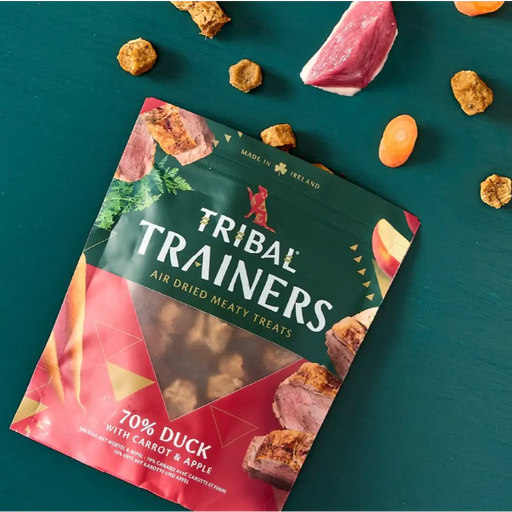 Tribal Trainers air dried meaty treats packaging on a teal background with treats around it.