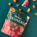 Tribal Trainers air dried meaty treats packaging on a teal background with treats around it.