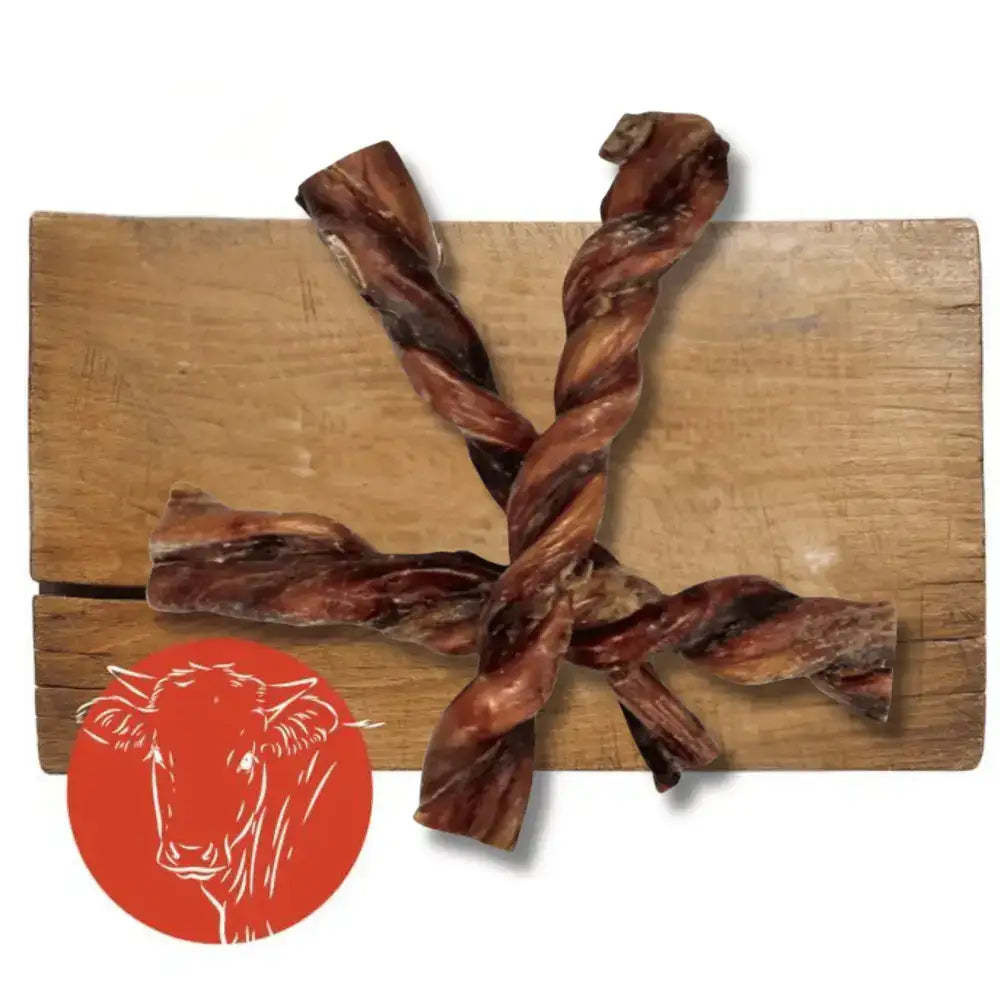 Twisted, dark brown beef jerky treats arranged in a cross on a wooden board.