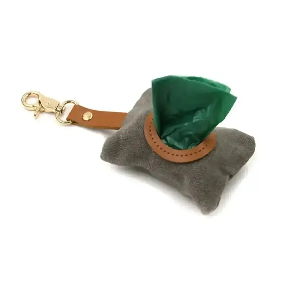 Gray waxed canvas poop bag holder with green liner, tan leather strap, gold clip