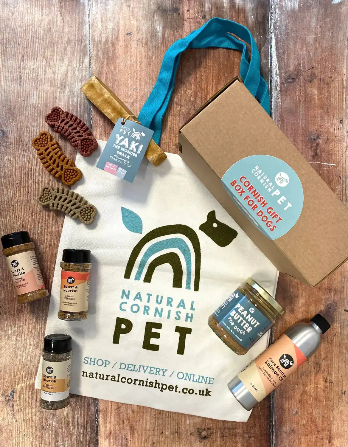 White canvas tote bag with green and teal rainbow dog logo and ’natural cornish pet’ text.