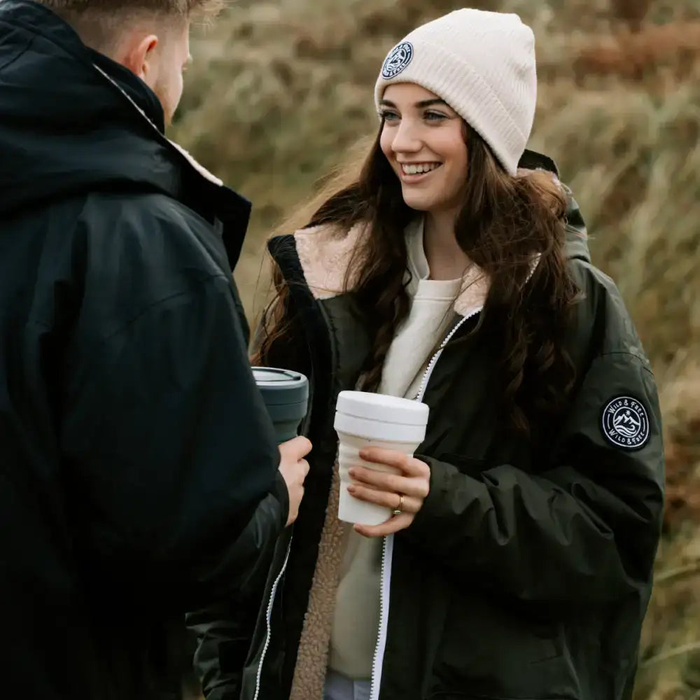 White collapsible travel mug held in a woman’s hand