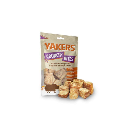 Yakers Crunchy Bites sits on a white background, a hand full of bites can be seen in front of the bag in the foreground